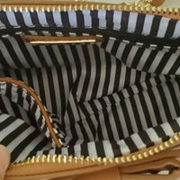 Mini tan cross body bag with bow detailing on front. Inside view.
