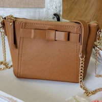 Mini tan cross body bag with bow detailing on front.
