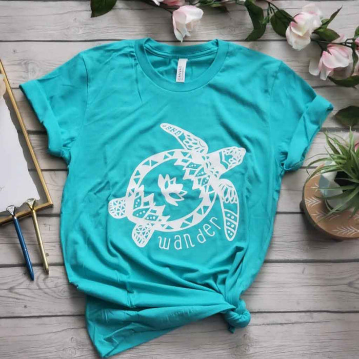 Teal color shirt with a groovy turtle and the quote "wander". 